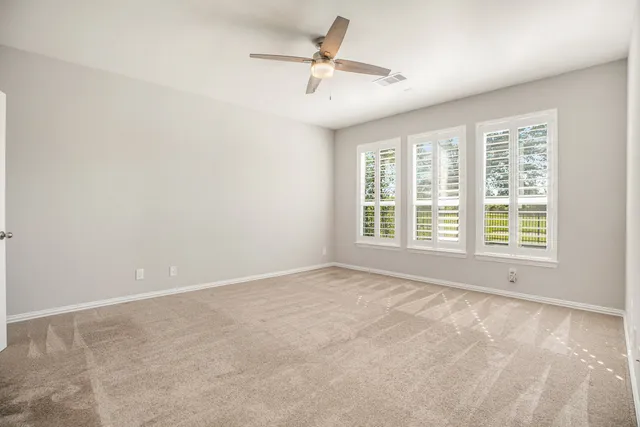 a view of a room with a ceiling fan and window