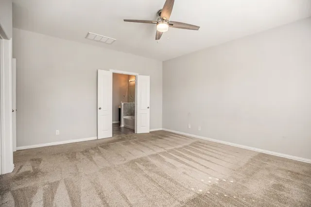 a view of an empty room with a ceiling fan