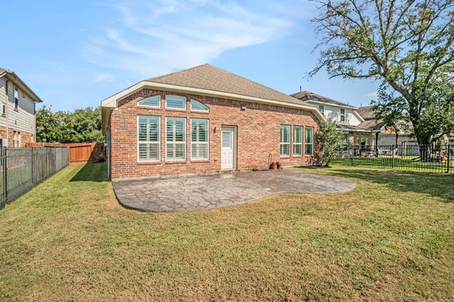 a view of a house with backyard and trees