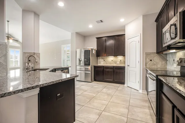a large kitchen with a stove a sink and a refrigerator