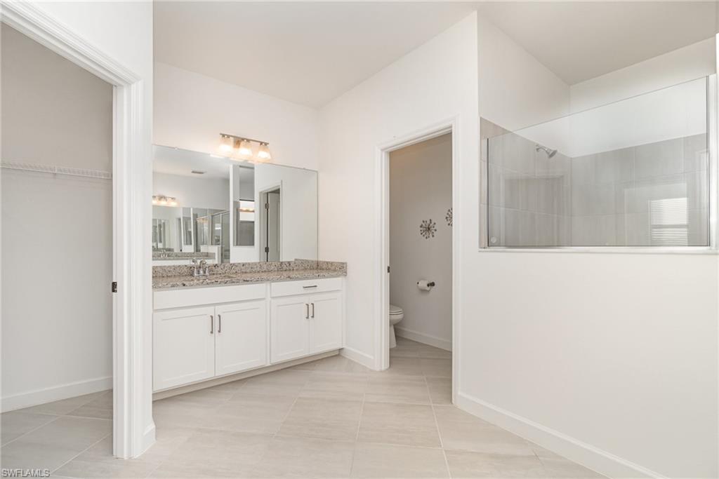 11127 Canopy Loop Fort Myers, FL 33913 - Photo 9 of 29 Bathroom with vanity, a walk in shower, and light tile patterned floors