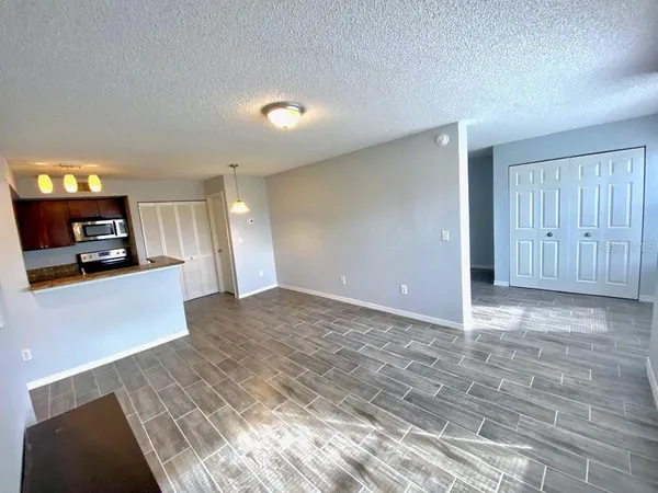 a view of a kitchen with kitchen island wooden floor and living room