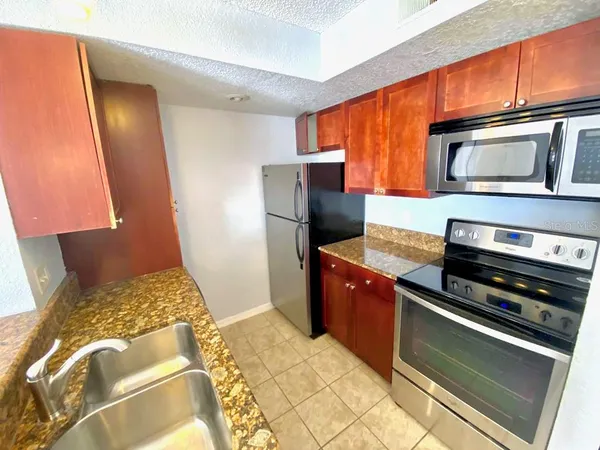 a kitchen with stainless steel appliances granite countertop a refrigerator and a stove top oven