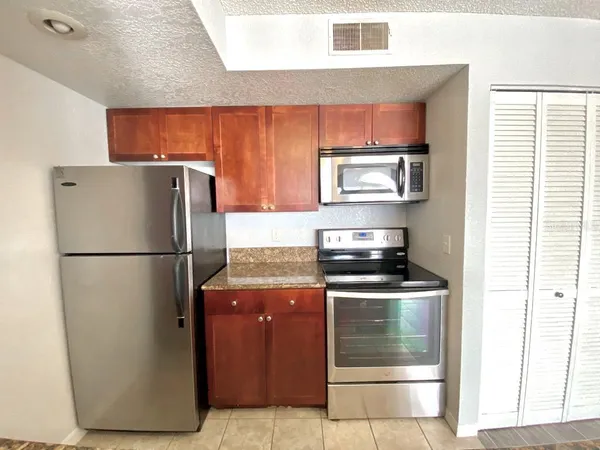 a kitchen with stainless steel appliances granite countertop a refrigerator and a stove