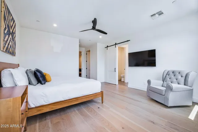 a bedroom with a bed and a flat screen tv