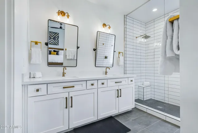 a bathroom with a double vanity sink a mirror and shower