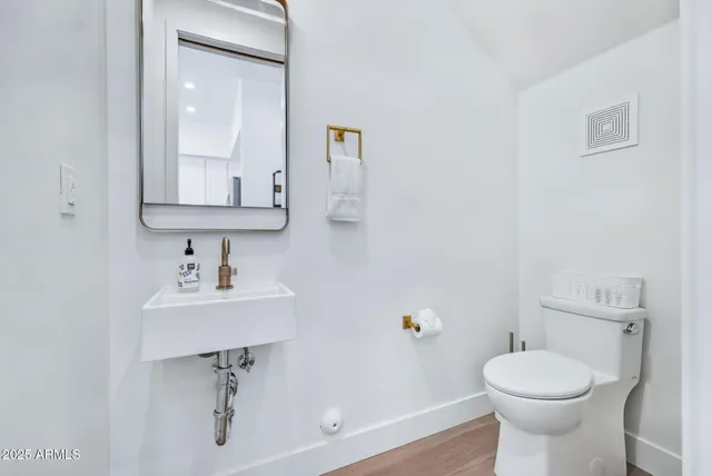 a bathroom with a sink toilet and a mirror
