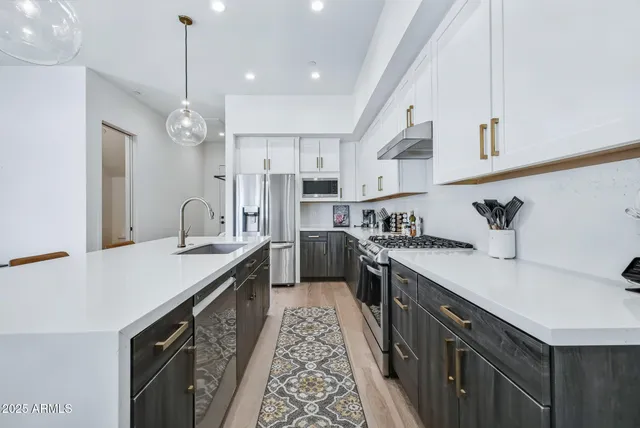 a kitchen with stainless steel appliances a sink stove and refrigerator
