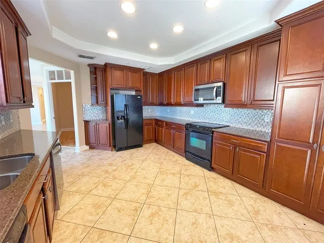 a kitchen with stainless steel appliances granite countertop a refrigerator sink and cabinets