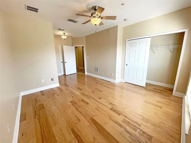 a view of an empty room with closet and a ceiling fan