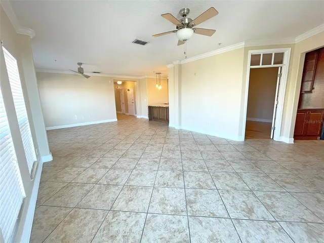 a view of a livingroom with a chandelier fan and windows