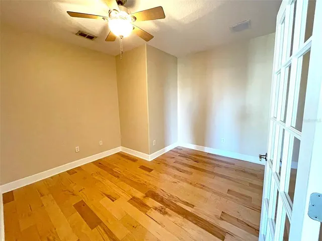 a view of empty room with window and ceiling fan