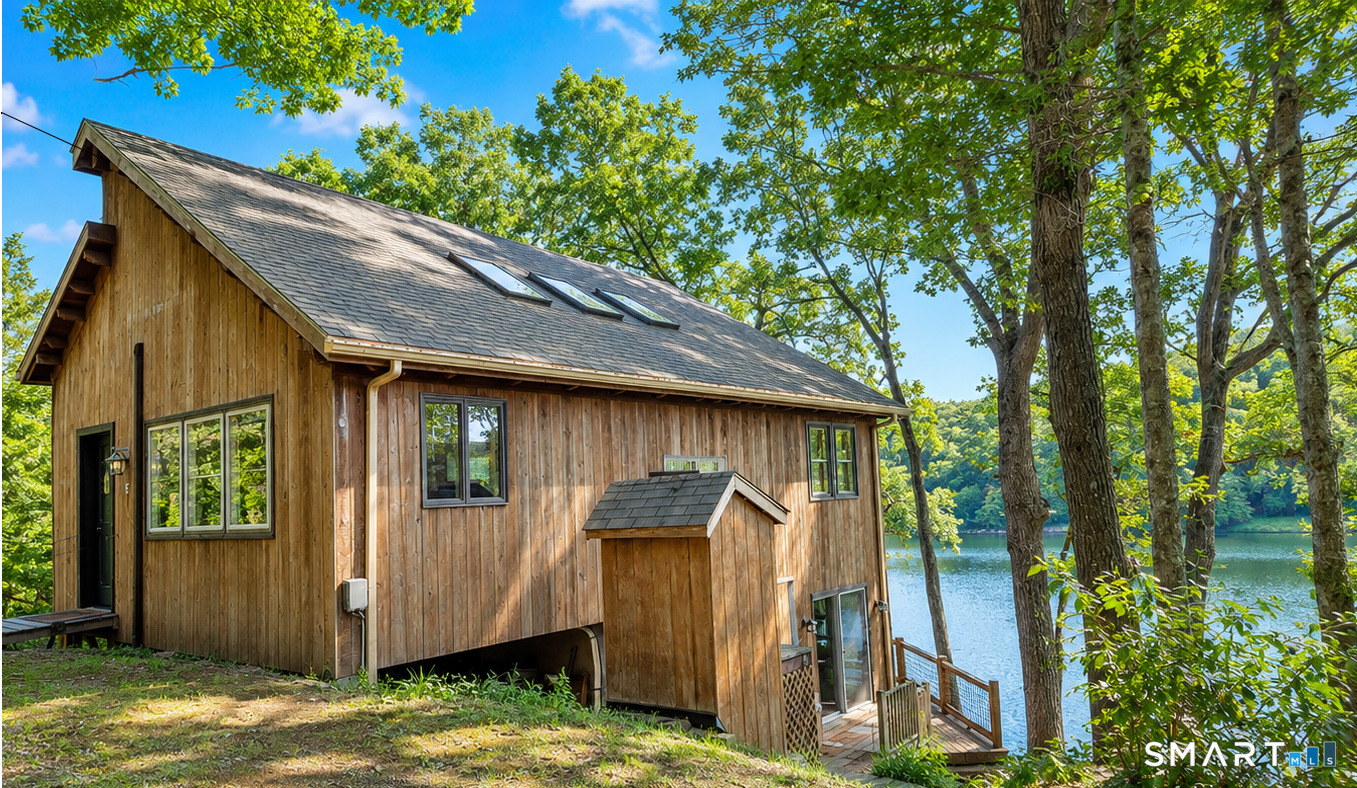 74 Cove Road, Unit 17 Haddam, CT 06424 - Photo 1 of 39 a backyard of a house with large trees and wooden fence