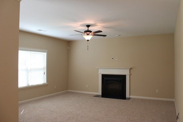 9300 Yarbrough Road Midland, GA 31820 - Photo 7 of 18 an empty room with a ceiling fan and a fireplace