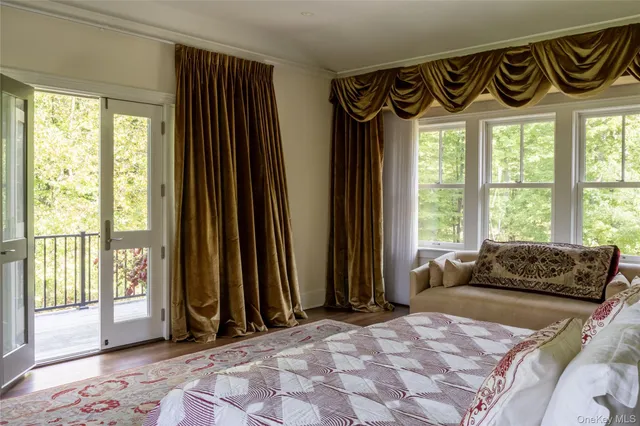 a bedroom with a bed and a large window