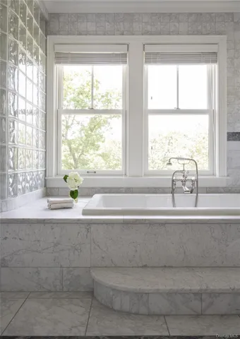 a bathroom with bathtub and window