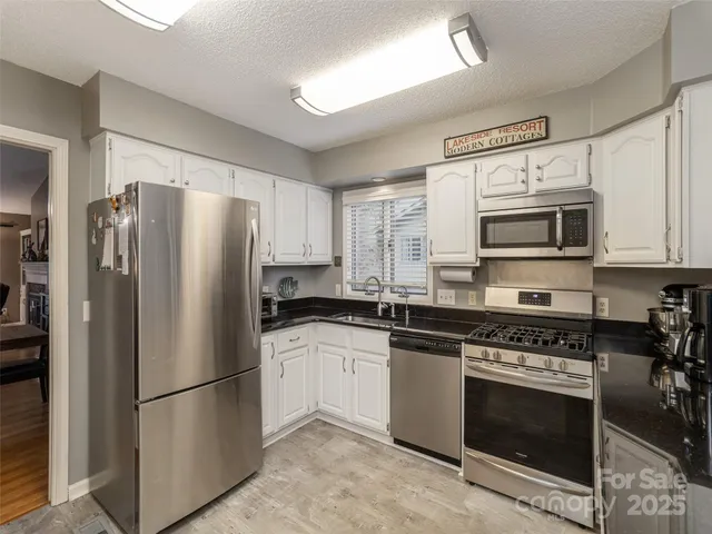 a kitchen with stainless steel appliances a refrigerator sink and microwave