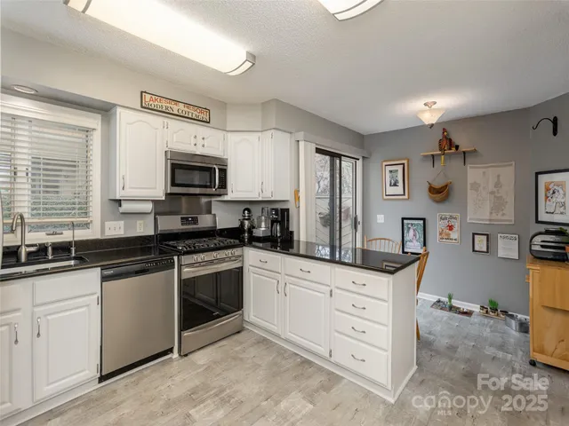 a kitchen with cabinets stainless steel appliances and a window