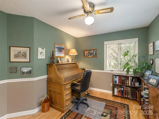 a view of a workspace with furniture and a window