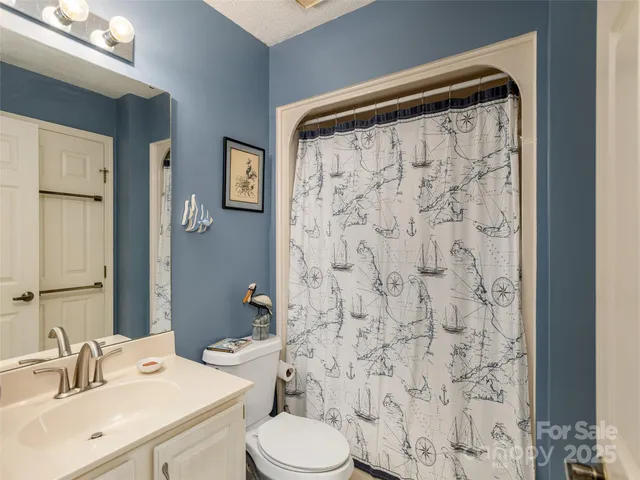 a view of a backyard with plants and large tree