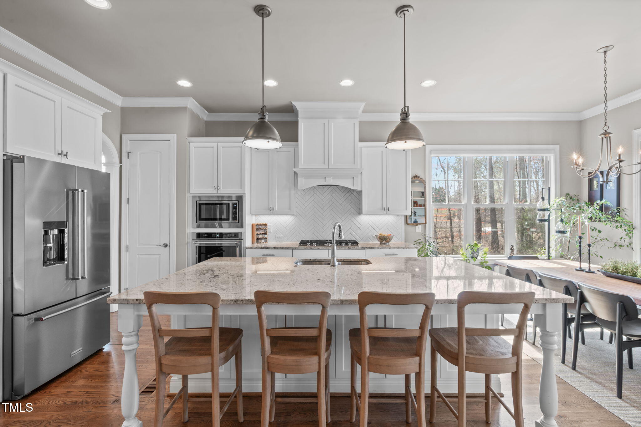2826 Walden Road Apex, NC 27502 - Photo 4 of 50 a kitchen with kitchen island a dining table chairs stainless steel appliances and cabinets