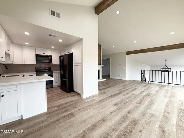 a view of kitchen with refrigerator microwave and cabinets