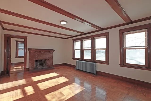 a view of an empty room with window and fire place