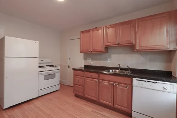 a kitchen with granite countertop wooden cabinets and a stove top oven
