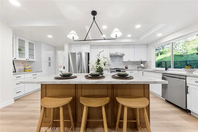 a kitchen with a sink chairs and cabinets