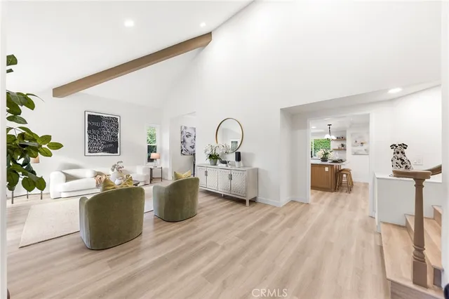 a living room with furniture a couch and dresser with wooden floor