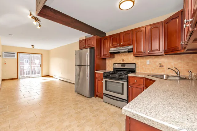 a kitchen with granite countertop a refrigerator stove top oven and sink