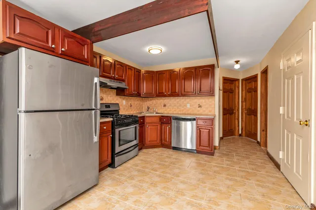 a kitchen with stainless steel appliances granite countertop a refrigerator a sink and a stove