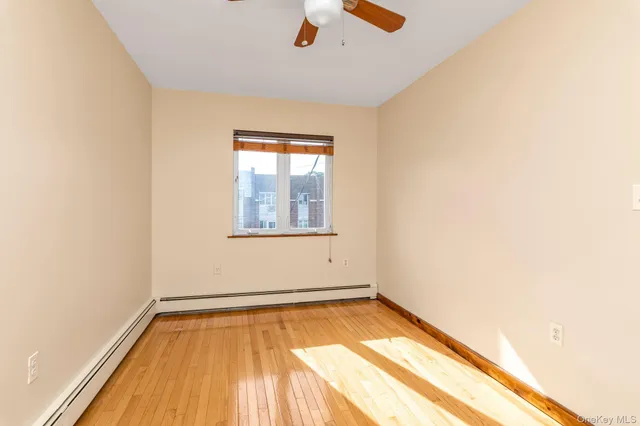 an empty room with a window and wooden floor