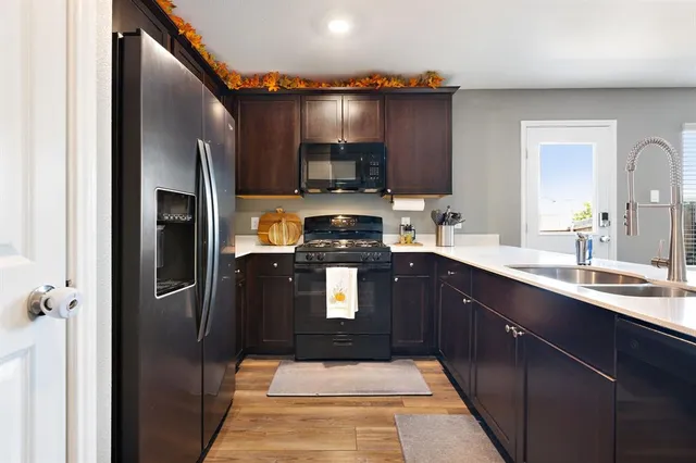 a kitchen with stainless steel appliances granite countertop a refrigerator a sink and wooden cabinets