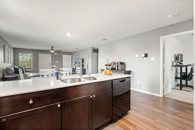 a kitchen with a sink cabinets and wooden floor