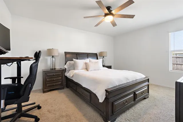 a bed room with a bed and a ceiling fan