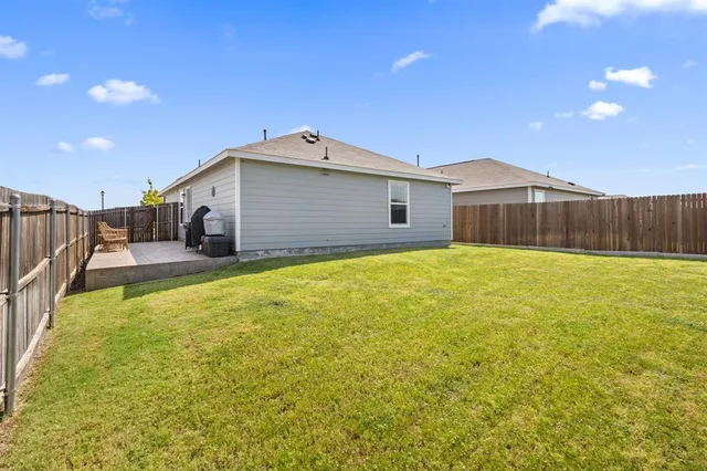 a view of a house with a backyard and a tree