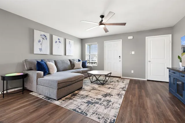 a living room with furniture and a wooden floor