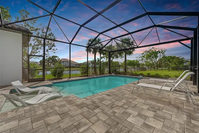 an aerial view of ocean and residential houses with outdoor space