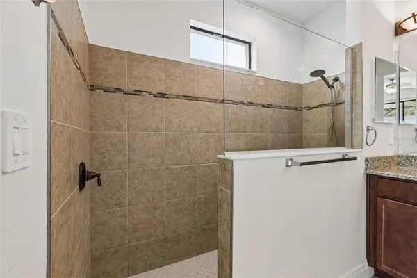 a bathroom with a granite countertop sink a toilet and shower
