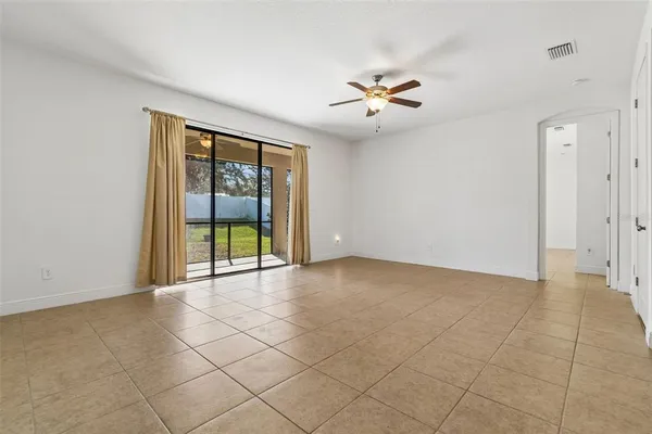 a view of an empty room with a fireplace and a large tree