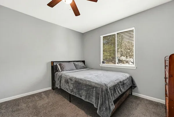a bed sitting in a bedroom next to a window