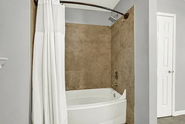 a bathroom with a shower and a bath tub