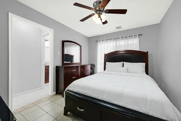 a bedroom with a bed and a mirror on the dresser