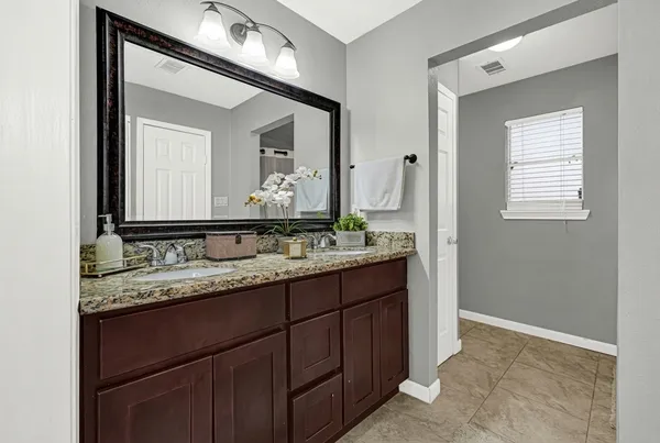 a bathroom with a granite countertop sink vanity and mirror