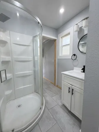 a bathroom with a tub sink and mirror