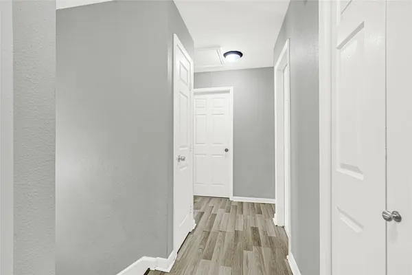 a view of a room with wooden floor and a bathroom