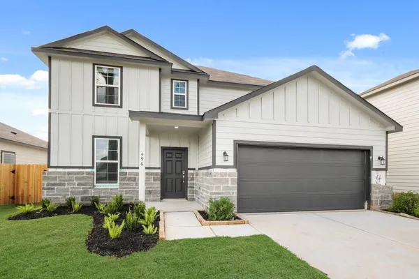 a front view of a house with a garden and plants