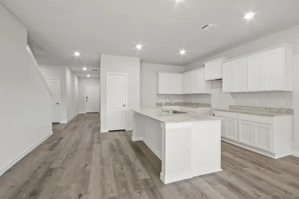 a kitchen with a white wooden cabinets stove top oven and refrigerator