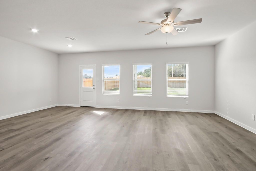 496 Shoreview Drive Conroe, TX 77303 - Photo 6 of 20 a view of an empty room with a window and wooden floor